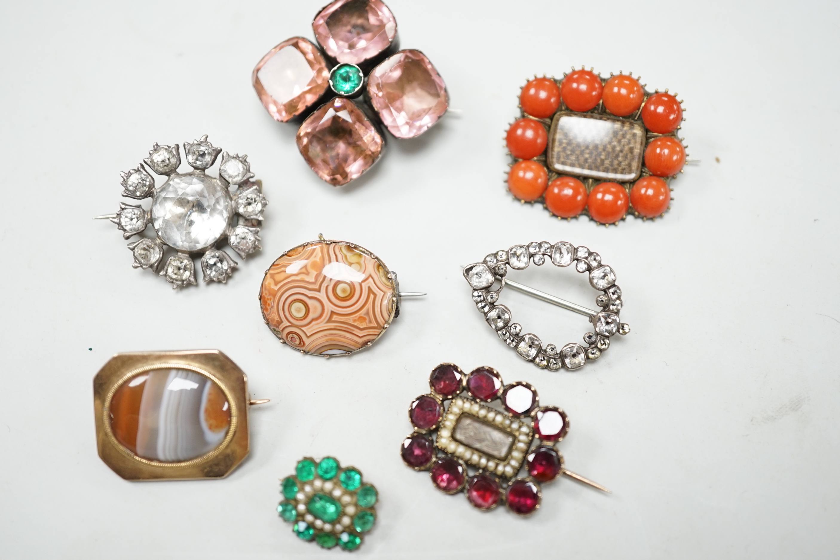 Eight assorted mainly 19th century items of jewellery, including four paste set brooches, garnet, seed pearl and plaited hair mourning brooch, a similar coral and plaited hair brooch and two chalcedony set brooches.